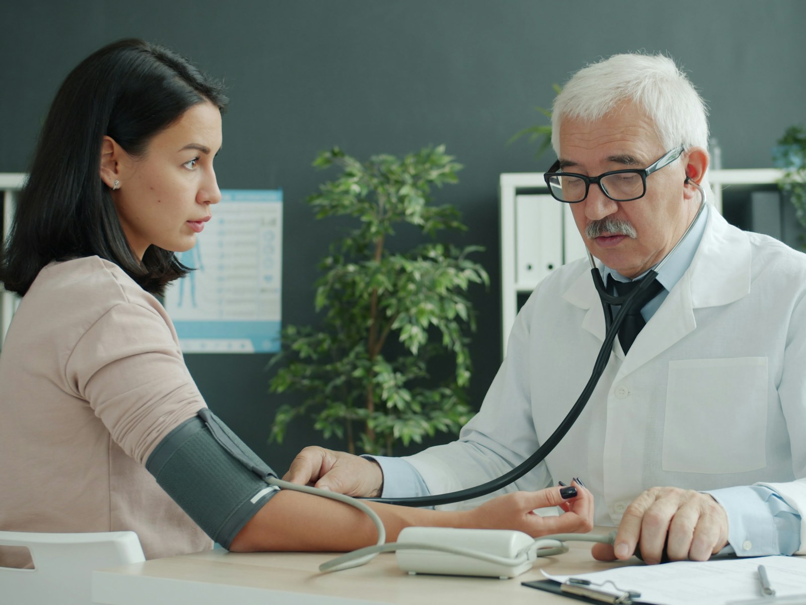 A doctor listening to a patient's heart with a stethoscope