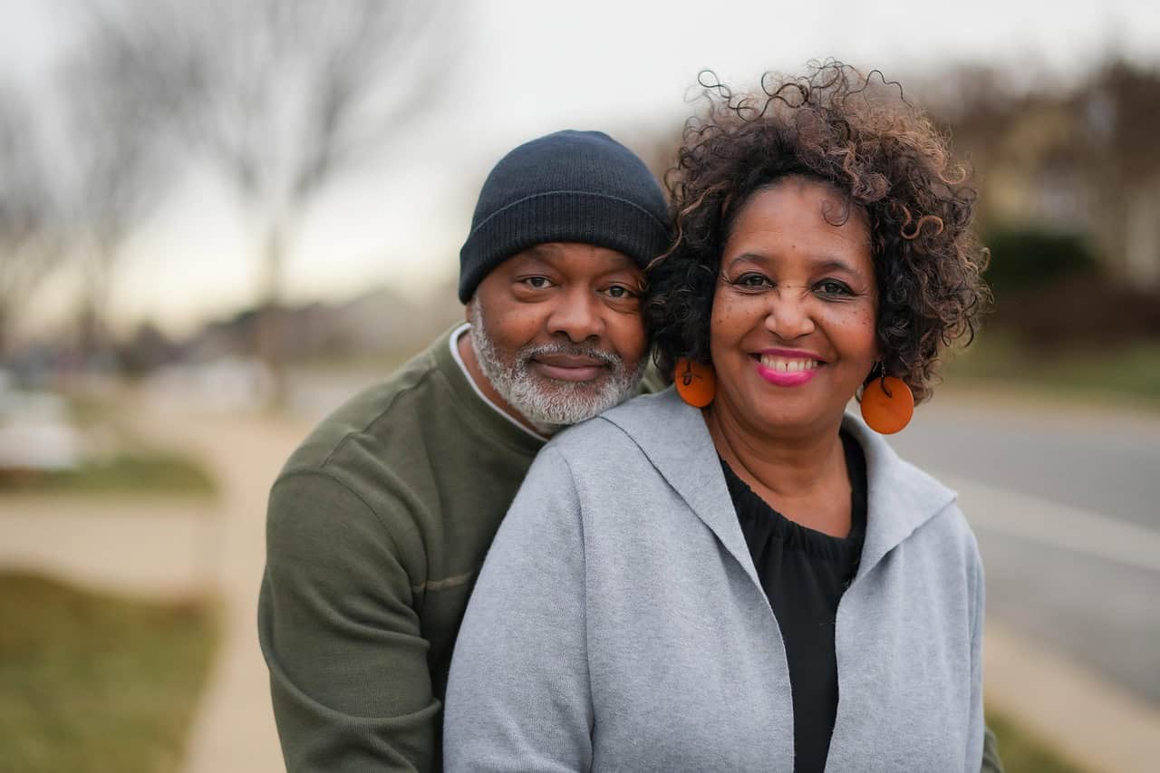A smiling older couple embracing outdoors