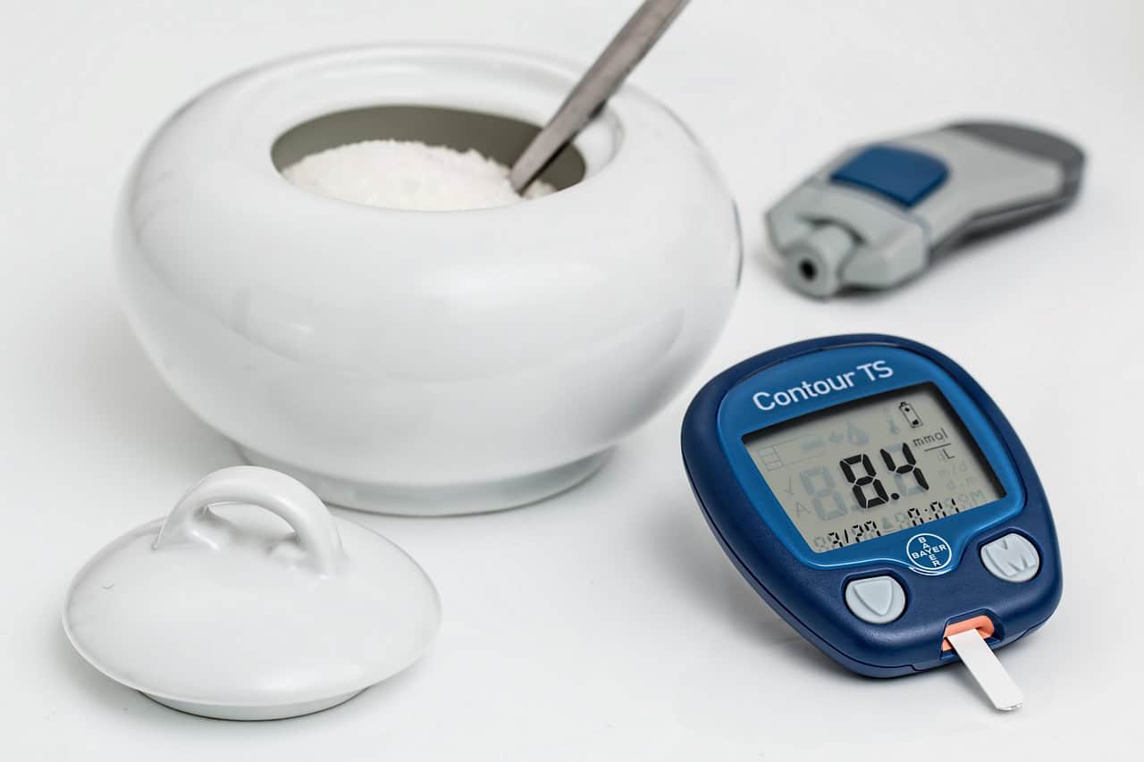 A blood glucose meter and test strip on a table