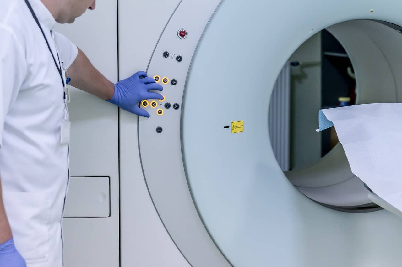 A technician at the controls of an MRI scanner