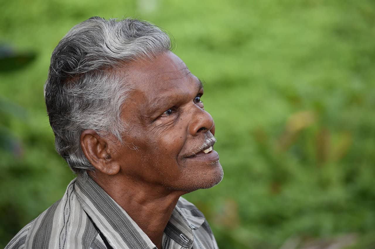A smiling older man with gray hair outdoors
