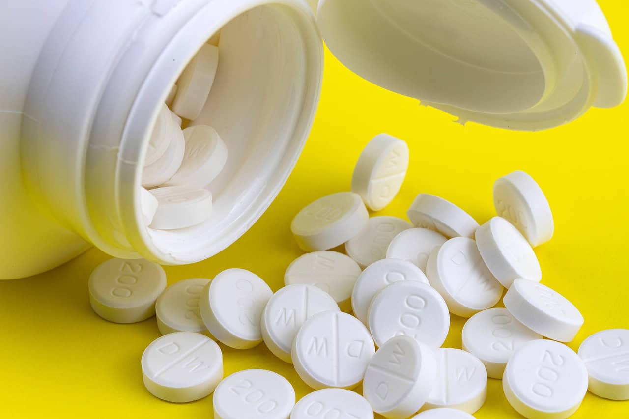 White prescription pills spilling from a bottle