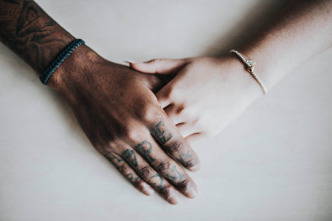 One person resting a hand on another’s in support