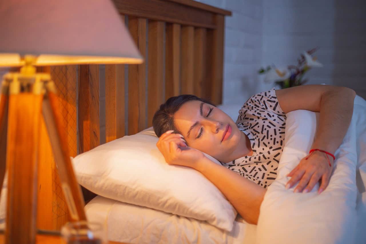 A woman asleep on her pillow in a softly lit bedroom